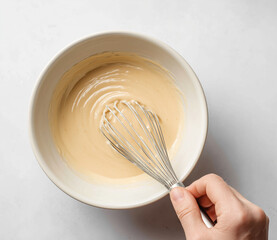 Chef whisking ingredients in bowl for baking or cooking