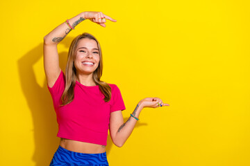 Cheerful young woman in a colorful outfit gesturing enthusiastically against a bright yellow...