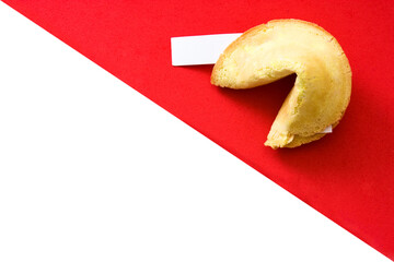 Fortune cookie revealing a blank fortune on red and white background