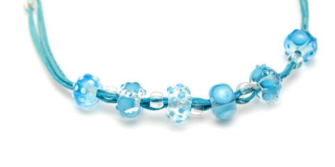 a simple necklace of blue and transparent glass beads isolated on white background 