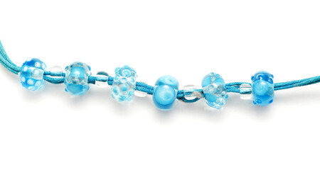 a simple necklace of blue and transparent glass beads isolated on white background 