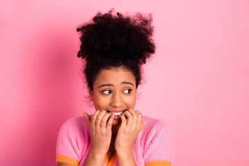 Young woman expressing nervousness with hands near face on pink background showcasing casual...
