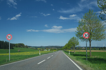 Landstraße mit doppelter Beschilderung Verkehrsschild Verkehrszeichen Zulässige Höchstgeschwindigkeit 50  - Stockfoto
