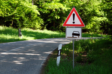 Straße und Verkehrsschild mit Verkehrszeichen Gefahrstelle und Zusatzschild Unbefestigter Seitenstreifen - Stockfoto