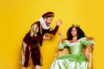 Elegant Couple in Medieval Costumes Displaying Royalty on a Bright Yellow Background