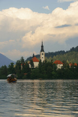 very small island on natural bled lake in summer with church in middle and beautiful green trees...