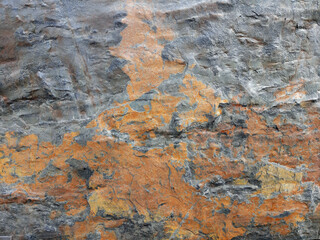 Gray and orange stone surface forming natural background with texture.