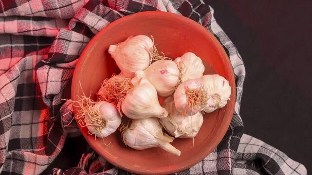Closeup of a rotating shot of garlic in a mud bowl