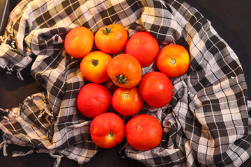 Fresh red tamotoes with kitchen cloth and kept in a bowl, healthy vegetable in the kitchen