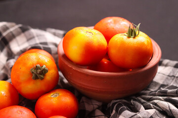 Fresh red tamotoes with kitchen cloth and kept in a bowl, healthy vegetable in the kitchen