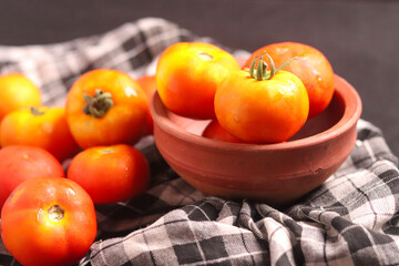Fresh red tamotoes with kitchen cloth and kept in a bowl, healthy vegetable in the kitchen