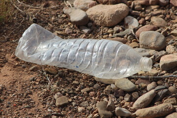 A plastic bottle lying on the ground, Plastic pollution, Plastic environmental impact