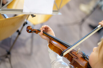Young musician plays violin during afternoon music class in a cozy studio, showcasing dedication...