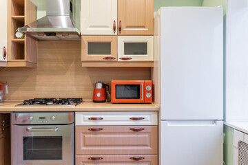 wooden built-in cupboards in kitchen. Brown furniture in kitchen. Bright kitchen furniture design....