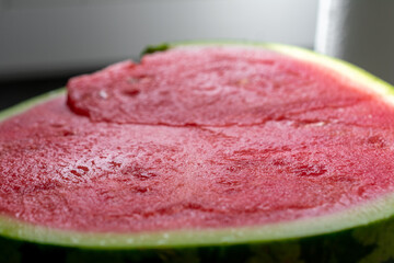 Slice of watermelon with a red spot on it. The watermelon is cut in half.