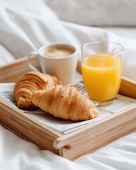 Breakfast in bed with croissants, coffee and orange juice