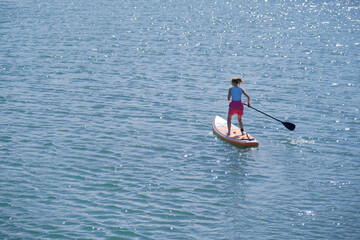 Fototapeta premium woman rowing sup board on sea water , paddleboard and surfing