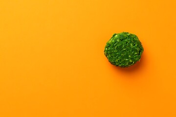 Green ball on solid orange background