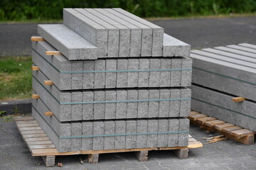 Edging stones on a wooden pallet on a building site, infrastructure sector