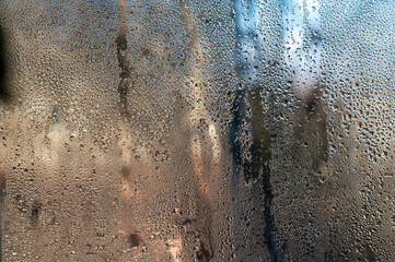 Humid indoor air it forms water droplets and condensation on wet glass. abstract with glass...