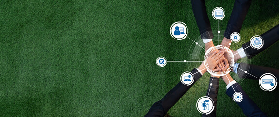 A diverse business team collaborates on a green grass surface, showcasing unity and modern...