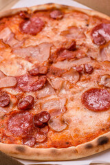 Italian pepperoni pizza with cheese and salami, tomatoes and sauce
