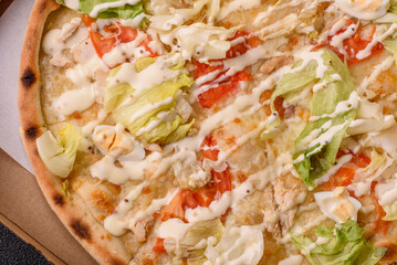 Italian caesar pizza with cheese and chicken, lettuce leaves and sauce