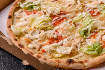Italian caesar pizza with cheese and chicken, lettuce leaves and sauce