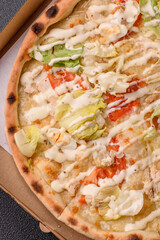 Italian caesar pizza with cheese and chicken, lettuce leaves and sauce