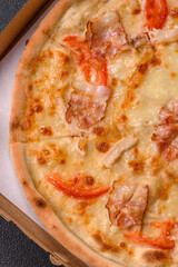 Italian pizza with chicken and bacon, cheese, tomatoes and sauce