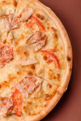 Italian pizza with chicken and bacon, cheese, tomatoes and sauce