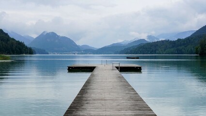 lake in the mountains with walkway for swimmers with  mountains and cloudy sky in backdrop