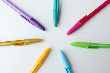 Set of colorful ballpoint pens arranged in circle on white background. Perfect for creativity, drawing, art class, artistic study, kids education and back to school themes. Stationery, office supplies