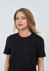 Obraz premium Blonde model poses stylishly in a black shirt for studio fashion shoot
