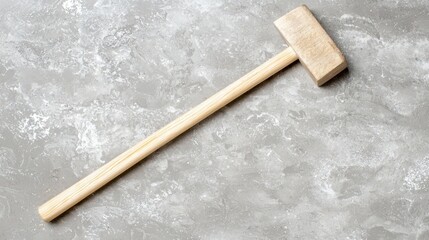 A wooden mallet on a concrete surface.