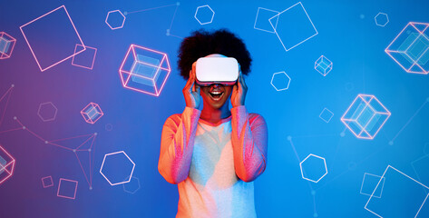 African girl with VR glasses standing at blue and pink background and looking at floating geometric shape. Excited person searching and entering visual reality world. Technology innovation. Ingenuity.