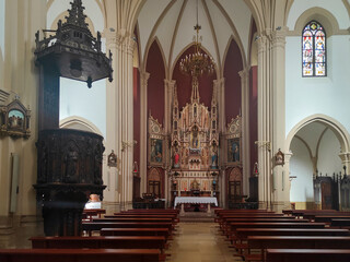 Interior of catholic church showing wooden pews, pulpit, and altar