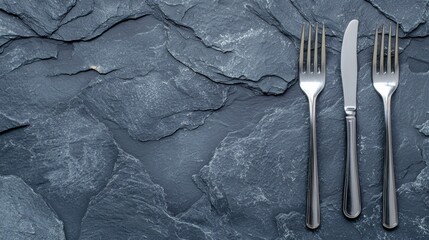 A black background with three forks and a knife.