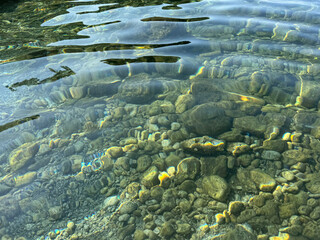 Crystal clear sea water with pebbles and stones.