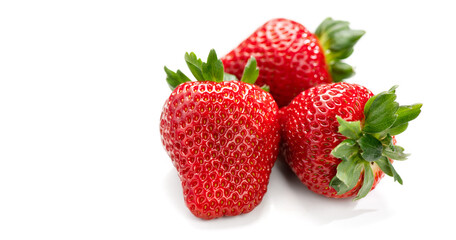 Strawberry isolated on white background. Three Fresh ripe organic strawberries, macro shot of fresh juicy berries, top view, close up, flat lay 