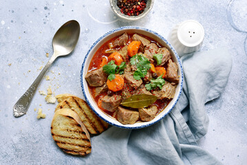 Goulash (meat stew with tomatoes and paprika) - traditional dish of hungarian cuisine .Top view with copy space.