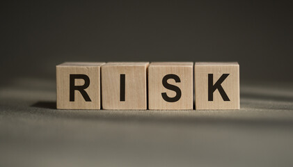 Risk assessment, decision to accept business result in uncertainty, unpredictable situation concept, cube wooden block with alphabet building the word RISK.