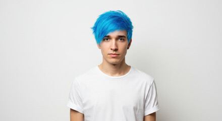 Trendy Young Man with Bright Blue Hair in White T-shirt Standing Against Plain Background