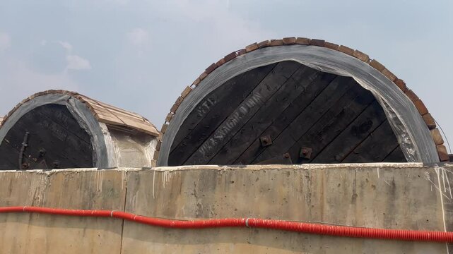 Large Wooden Industrial Drums Behind Concrete Wall