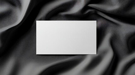 Naklejka premium Blank white card on dark fabric