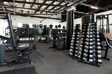 Gym interior equipped with weights and various exercise tools, creating environment for strength...