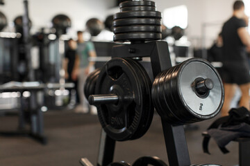 Various weight discs on its vertical stand in the gym, closeup shot