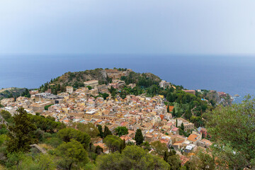 Fototapeta premium View from above Taormina with the medieval city center, the ancient greek theater and the coastline visible on Sicily, Italy 