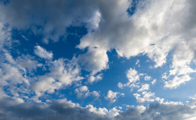 Blue sky with fluffy white clouds. Wide format. Puffy cumulus clouds mixed with blue sky