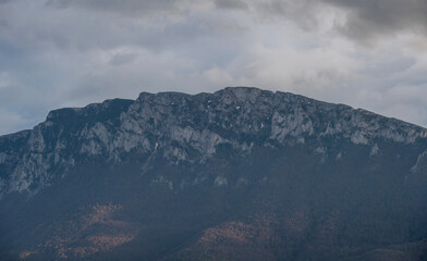 Fototapeta premium View of the Suva Planina mountain range. Open landscape photography. The sun shines on a huge mountain rock on top of the mountain. Mountain peaks in the woods landscape. Photo nature. 